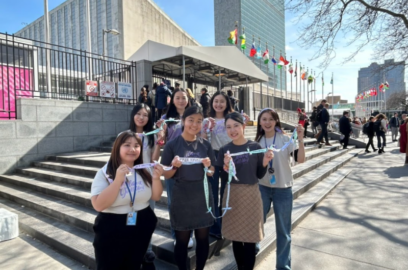 The delegate members of YWCA of Japan, holding a ribbon with messages for peace and gender equity.